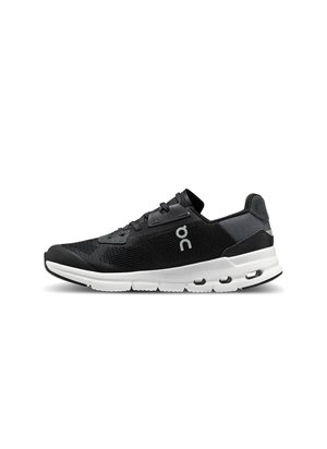 Schwarzer Sportschuh mit einem strukturierten Mesh-Obermaterial, weißer Sohle und verstärktem Fersenbereich. Verfügt über ein Schnürsystem und ein Logo an der Seite.