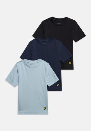 Trois t-shirts unis à manches courtes en bleu clair, bleu marine et noir, chacun avec un petit logo d'oiseau jaune près de l'ourlet inférieur.
