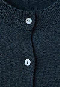 Námornícky pletený kardigán s rebrovaným golierom a dvoma bielymi guľatými gombíkmi. Textúra je hladká s jemným vzorom.