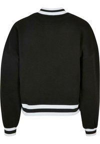 Musta cropped-mallinen collegepaita, jossa valko-mustaraidallinen resoripääntie ja -hihansuut. Sileä pinta, pitkät hihat ja leveä malli.