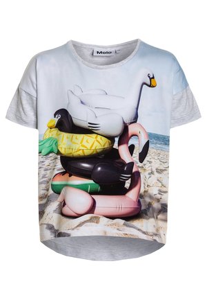 T-shirt à manches courtes avec un graphique de jouets de piscine gonflables empilés, dont un cygne, un flamant rose et un canard, sur fond de plage.
