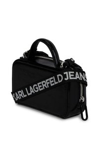 Czarna, lakierowana skórzana torebka prostokątna z górnym uchwytem, srebrnym zamkiem błyskawicznym oraz czarnym paskiem z białym napisem "KARL LAGERFELD JEANS".