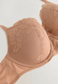 Hautfarbener BH mit Spitze und floralem Muster, durchsichtigen Netz-Cups und glatten Stoffträgern. Zarte Designelemente überall.