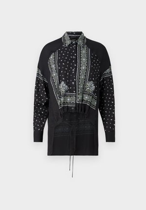 Camisa negra con una mezcla de estampados de paisley y geométricos, con cuello de camisa, mangas largas y un detalle de cintura ajustada.