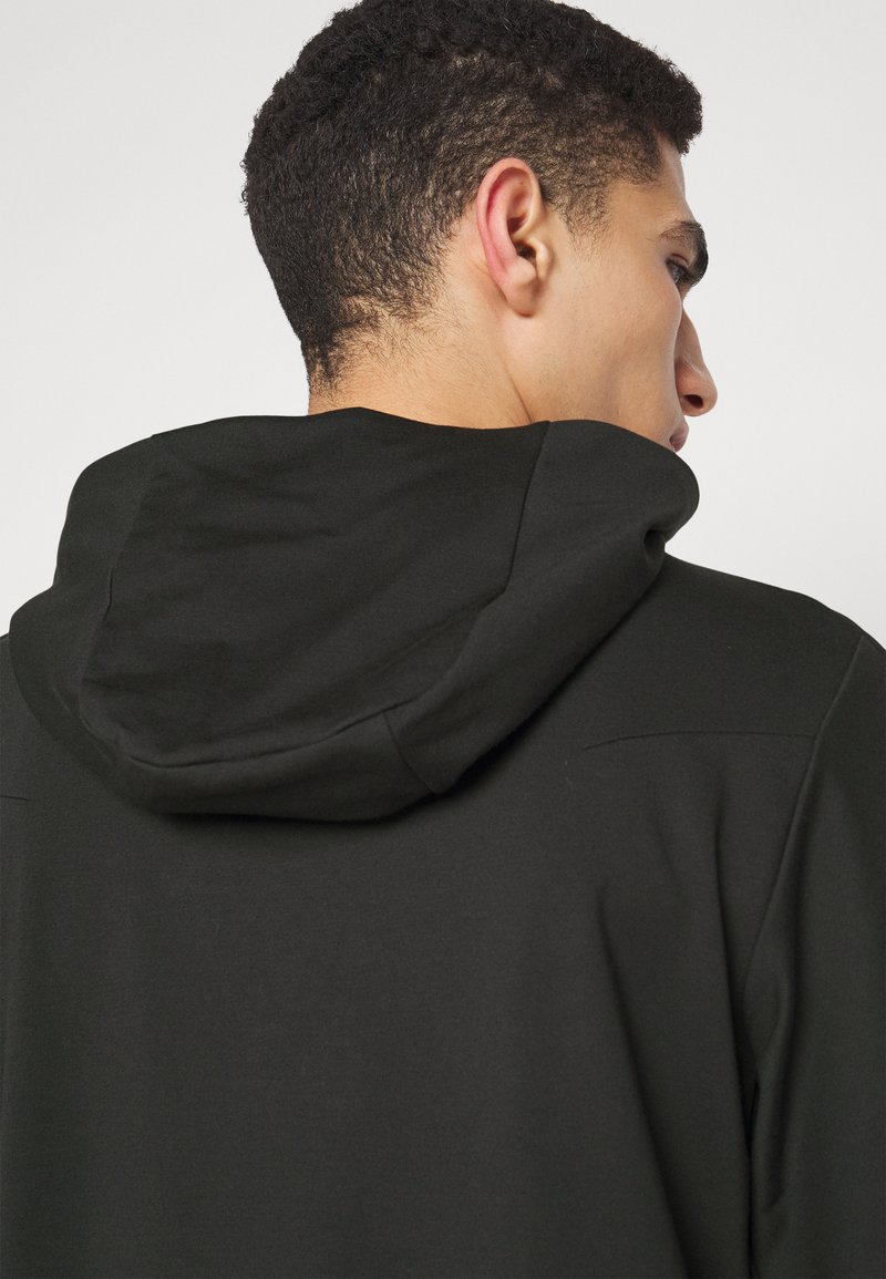 Felpa nera con cappuccio arrotondato, texture liscia e dettagli di cucitura minimal sul retro, progettata per un fit confortevole.