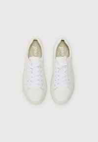 Hvite skinn-sneakers med rund tå, flate hvite snørebånd og et enkelt design. Interiøret har subtil merking på en lys bakgrunn.