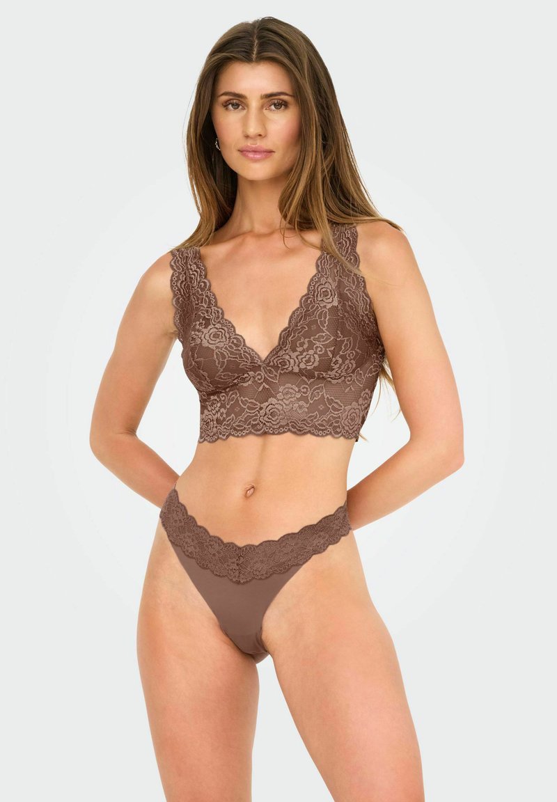 Brauner Spitzen-Bralette mit tiefem V-Ausschnitt und gewelltem Saum, kombiniert mit einem passenden Tanga, der ähnliche Spitzendetails aufweist. Glatte Textur.