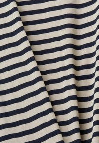 Tessuto di cotone con righe orizzontali in blu navy e crema. La trama è liscia e le righe variano in larghezza.