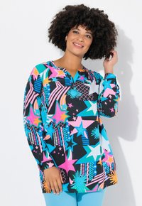 Tunica a maniche lunghe colorata con una combinazione di stelle, righe e forme geometriche in rosa, blu, giallo e nero realizzata in un tessuto leggero.