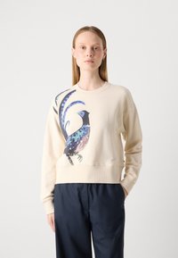 Sudadera beige de corte corto con puños acanalados, que presenta un gráfico de un pájaro colorido en tonos azules y morados en la parte delantera.