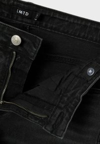 Svart denimjeans med dragkedja, knäppning och LMTD-märket. Funktioner inkluderar strukturerad tyg och en standard design på midjebandet.