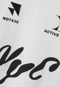 Balts auduma t-krekls ar lieliem melniem uzrakstiem un grafikiem, tostarp stilizētiem burtiem un ģeometriskām formām. Uzraksts ietver "NO7430" un "ACTIVE."