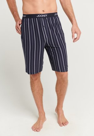 Marine randiga shorts gjorda av mjukt tyg med en svart midja som har varumärket "JOCKEY" samt en funktionell knappgylf.