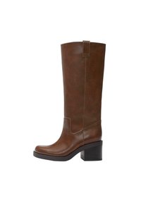 Cizmă maro din piele până la jumătatea gambei, cu toc gros, vârf rotund, buclă pentru tras în partea de sus și cusături vizibile de-a lungul părților laterale și în zona gleznei.