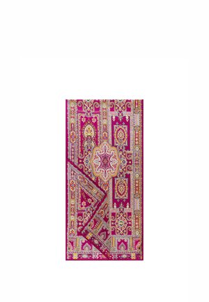 Bright pink and multicolored patterned textile with intricate floral and geometric designs, folded at one corner on a white background.