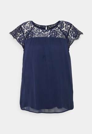 Blusa azul marino de manga corta con detalle de encaje floral en la parte superior del pecho y las mangas, escote redondo y cierre en la parte trasera con abertura en forma de ojo de cerradura.