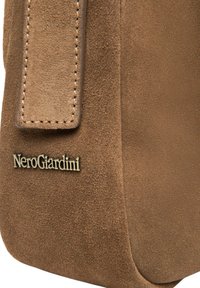 Borsa marrone in suede con una texture liscia, dotata di un manico cucito e dettaglio del logo "NeroGiardini" in oro.