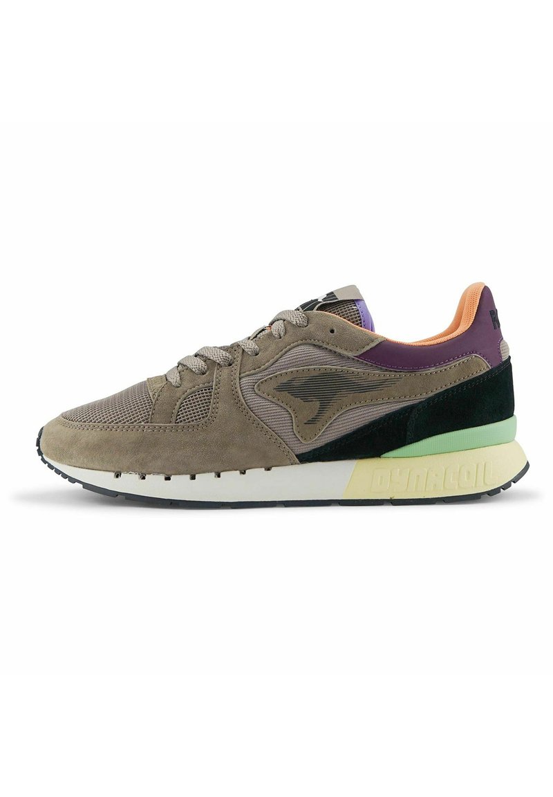 Sneaker con una combinazione di suede marrone e tomaia in mesh, accenti neri e verdi, pannello posteriore viola e suola bianca con il testo "DYNACOIL".