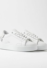 Sneakers bianchi con un esterno in pelle liscia, punta rotonda, chiusura con lacci e suola in gomma texturizzata. Silhouette slim con accenti minimi.