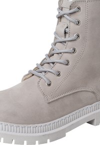 Botín de tobillo de cuero color gris claro con ojales metálicos, cordones grises, parte superior texturizada y suela de goma blanca con detalles en relieve.