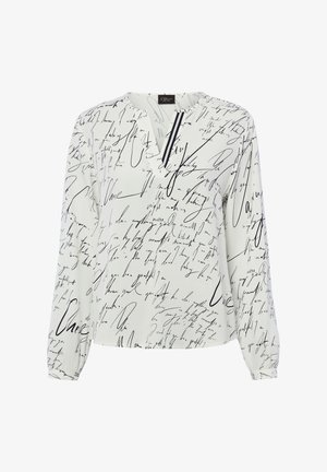 Witte blouse met lange mouwen, bedrukt met zwarte handgeschreven letters en een kleine V-hals met twee verticale zwarte strepen bij de halslijn.
