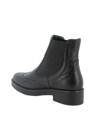 Stivale Chelsea in pelle nera con dettagli brogue sulla punta, pannelli laterali elasticizzati e tacco basso. Texture liscia e silhouette elegante.