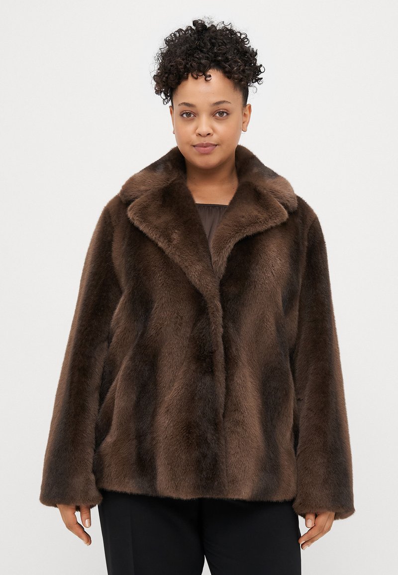 Brązowy płaszcz z sztucznego futra z szerokim kołnierzem, luźnym krojem i miękką fakturą. Posiada zapięcie na guziki oraz swobodny krój.