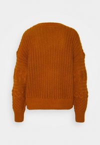 Stickad orange tröja med en texturerad, chunky design, med kabelstickade detaljer på ärmarna och en ribbad nederkant.