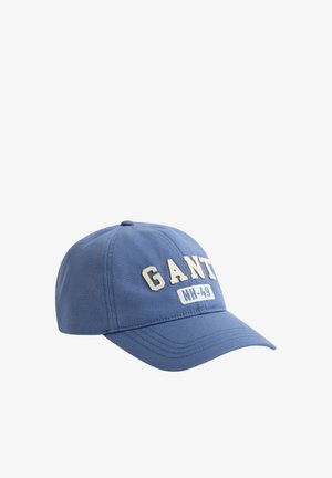 Blå baseballcaps med buet brem og forhøyede hvite bokstaver "GANT" samt en lapp med teksten "NH-49" på frontpanelet.