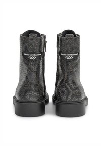 Bottes de cheville noires texturées reptile avec une finition lisse, dotées d'une fermeture éclair sur le côté et d'accents en forme de logo circulaire à l'arrière. Semelles en caoutchouc.