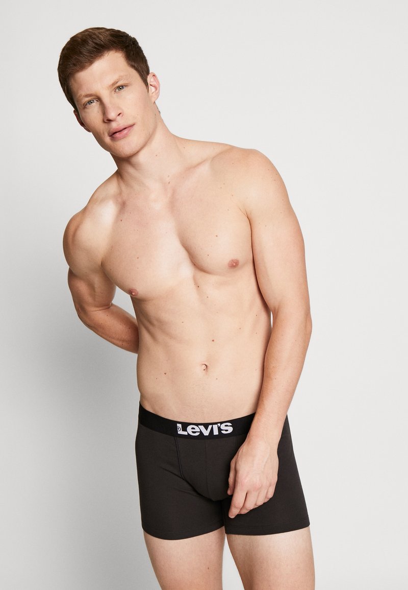 Schwarze Baumwoll-Boxershorts mit einem breiten elastischen Bund, der das Levi's-Logo trägt. Die Passform ist eng am Körper mit einer glatten Textur.