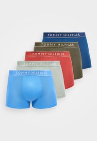 Cinq paires de boxers pour hommes pliés en bleu, vert clair, rouge, vert olive et marine, chacun avec une ceinture marquée "Tommy Hilfiger".