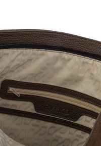Bruine lederen handtas interieur met beige voering, voorzien van een ritszak en een reliëfpatroon. Gestructureerde buitenrand, met ritssluiting.