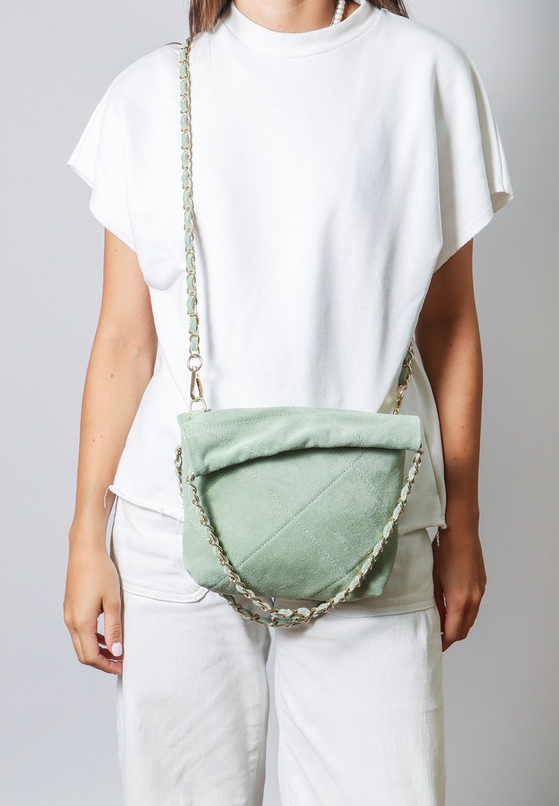 Borsa a tracolla verde in suede con un motivo a trapunto, hardware dorato e tracolla a catena con anelli alternativi verdi e dorati.