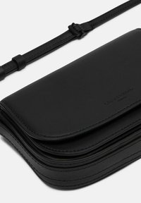 Schwarze Leder-Umhängetasche mit glatter Textur, Klappenverschluss und verstellbarem Tragegurt. Verfügt über dezente Markenkennzeichnung und Nähdetails.