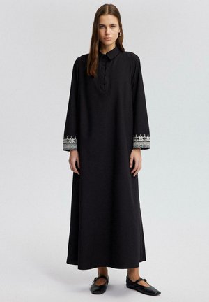 Black long dress with a collar, featuring long sleeves and intricate embroidery in white and gray at the cuffs. Simple design, soft fabric.