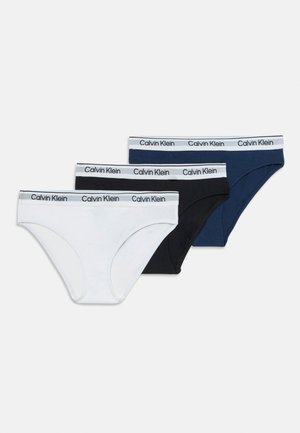 Troje pánskych slipov značky Calvin Klein v bielej, čiernej a námorníckej modrej farbe, s bielym pásom, na ktorom je opakovane potlačené čierne logo značky.
