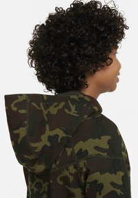 Felpa con cappuccio mimetica in verde scuro e marrone, dotata di un cappuccio ampio, tessuto testurizzato e dettagli di cuciture a contrasto.