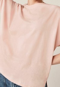 Kurze Ärmel, Blush-pink T-Shirt aus weichem Stoff. Verfügt über eine lockere Passform und einen runden Halsausschnitt, mit sichtbaren Nähten am Saum.