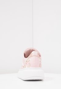 Baskets roses avec motif floral, cuir synthétique texturé, accents en or rose, col rembourré et semelle en caoutchouc blanche. Vue arrière.