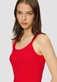 Rode geribde tanktop met brede bandjes en een aansluitende pasvorm. Kenmerkt een gladde textuur en een ronde halslijn.