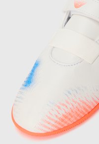 Valge sportlik jalanõu sinise ja oranži gradientkujundusega, velcro rihm, sile tekstuur ja oranž kummitald.