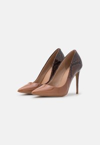 Décolleté con tacco alto, caratterizzati da un davanti lucido in nude, punta appuntita e un retro in stampa pitone marrone scuro testurizzato, con tacco a stiletto.