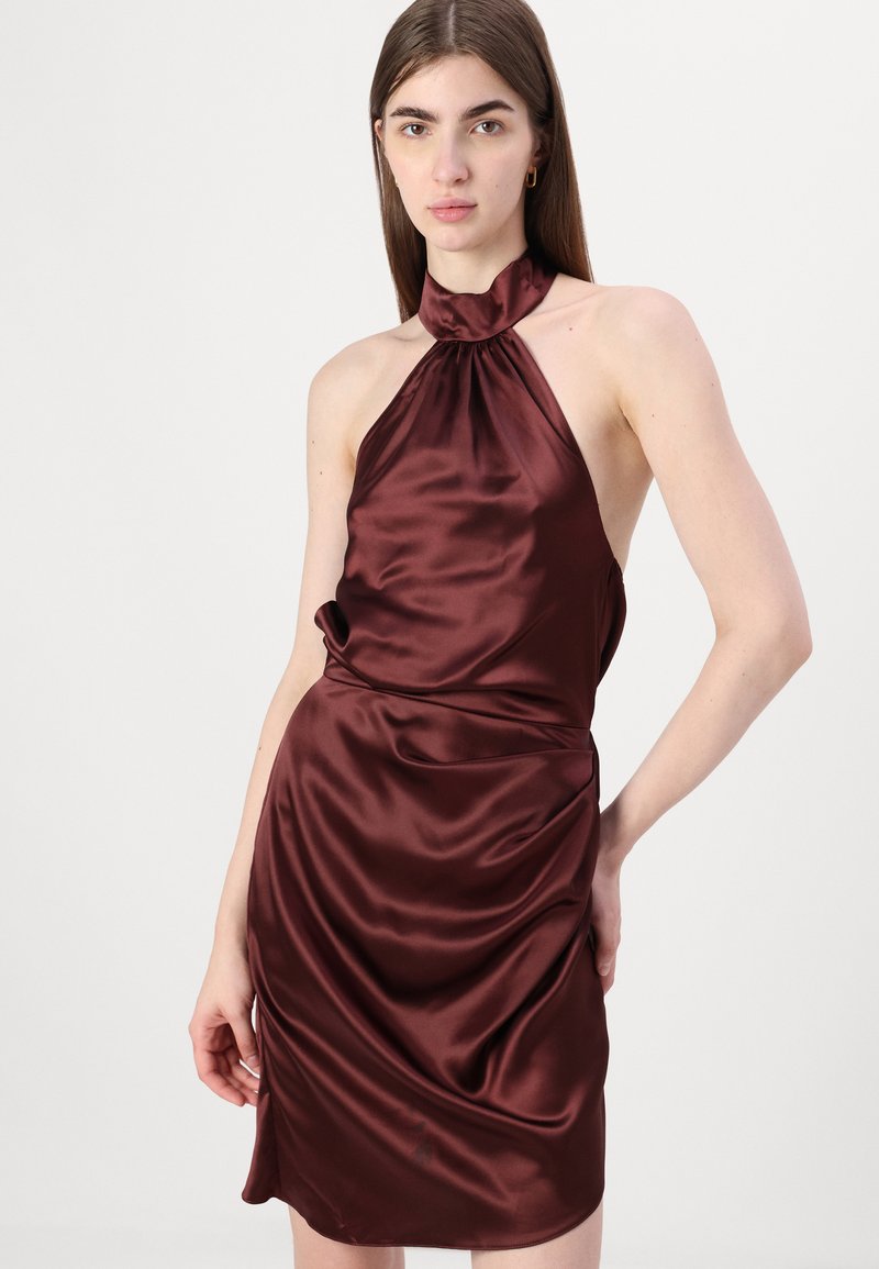 Burgundowa satynowa sukienka na ramiączkach z zebranym dekoltem, drapowanym materiałem i dopasowaną sylwetką, z odkrytymi plecami i detalami po bokach.