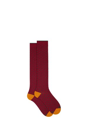 Bordeauxfarbene knielange Socken mit grünen Punkten, orangefarbigen Akzenten an der Zehe und Ferse. Hergestellt aus einem weichen, dehnbaren Material.