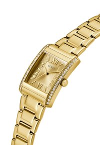 Gold-tone rectangular watch with a textured dial, Roman numeral markers, and embellished bezel. Features a linked metal bracelet and crown.