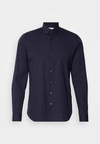 Chemise pour hommes à manches longues, bleu marine, à boutons, avec col pointu et logo discret sur la poitrine, sur fond uni.