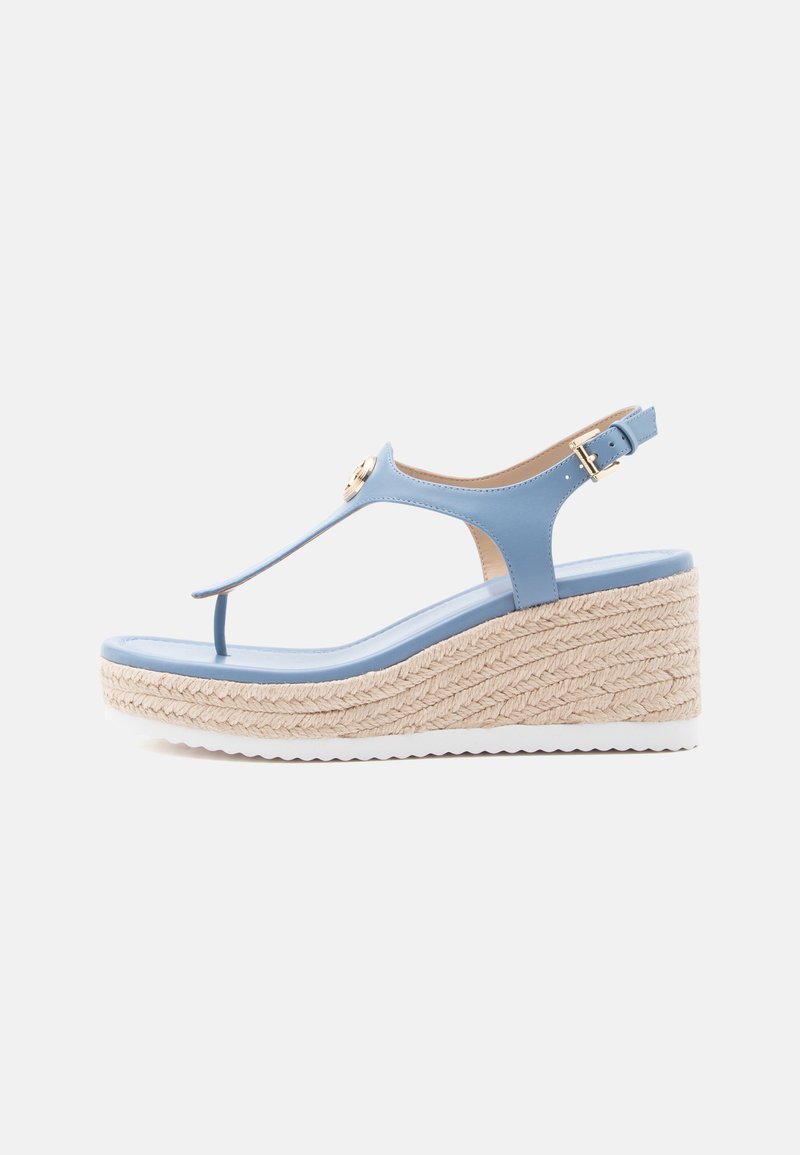 Sandale compensée bleu clair avec semelle en jute tressé, bride à la cheville avec boucle, et design à lanière entre les orteils sur fond blanc.