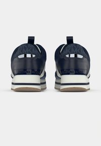 Ναυτικά αθλητικά παπούτσια με λείο υλικό, με επώνυμο τακούνι στο πίσω μέρος και ραβδωτή σόλα. Λεπτομέρειες με κοψίματα και υφασμάτινες πινελιές ολοκληρώνουν το σχέδιο.