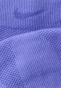 Μωβ κάλτσα Nike με ριμπ υφή, ομαλές πλεκτές λεπτομέρειες και διακριτικό λογότυπο της μάρκας υφασμένο στην επιφάνεια.